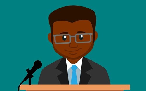 Animation of a dark-skinned man standing on a podium which has a microphone | © Unsplash